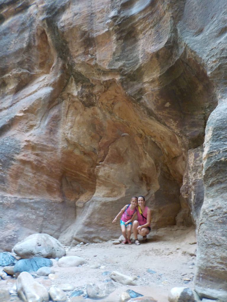 Mother and daughter near rock wall in The Narrows in Zion National Park