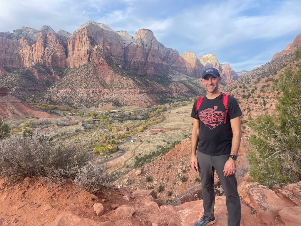 Man enjoying the view from the summit of Watchman Trail in Zion National Park