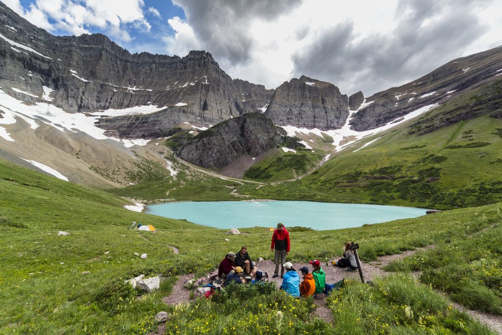 A group enjoys the view of Cracker Lake in Glacier National Park
