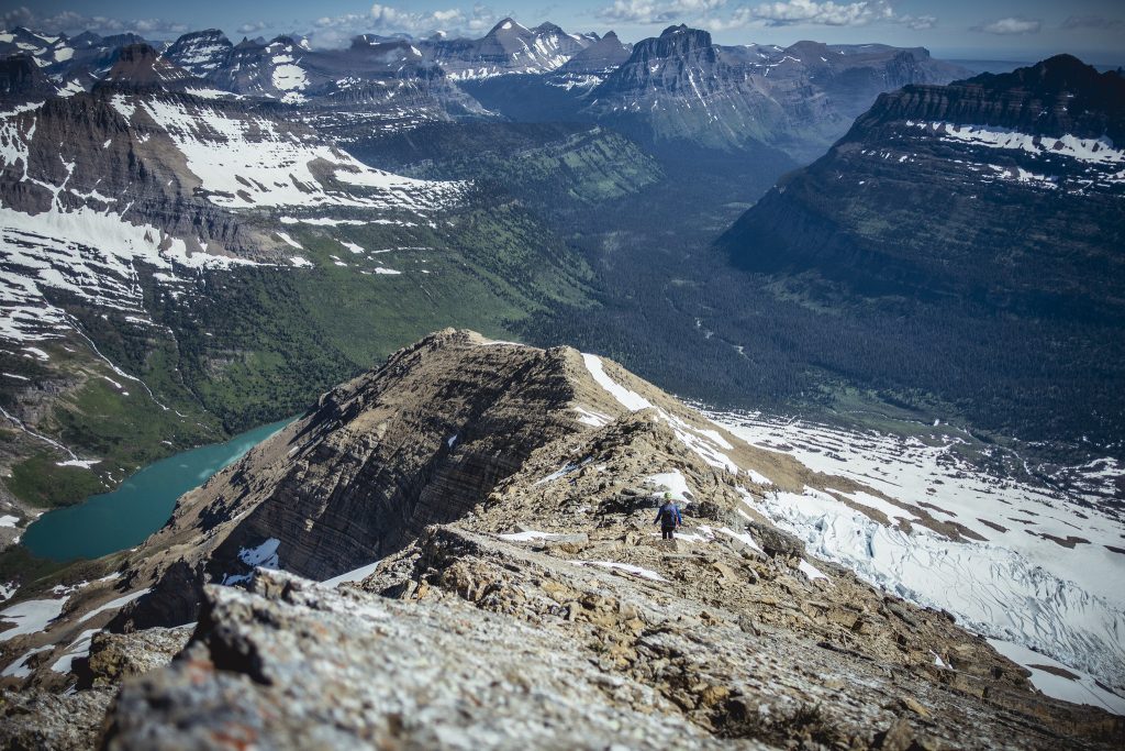 A hiker views Gunsight Lake from the Gunsight Pass trail in Glacier National Park