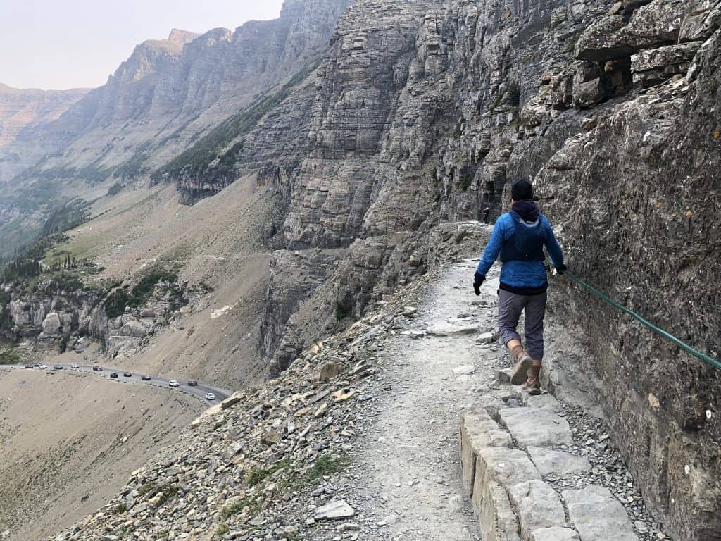 A hiker enjoying views from the Highline Trail, one of the best hikes in Glacier National Park.